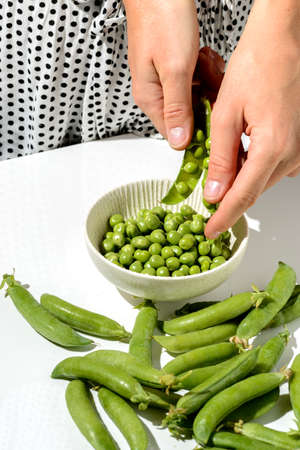 green peas and pods on a white backgroundの写真素材