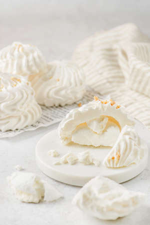 cut meringue white plate on white background. meringue is a dessert made of whipped proteins in sugar.の写真素材