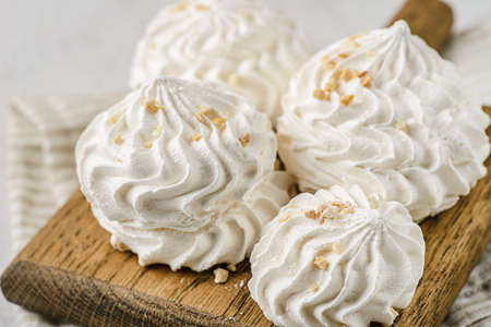 meringue on a wood on white background. meringue is a dessert made of whipped egg whites with sugar.の写真素材