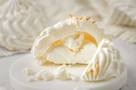 meringue cake with meringue cake in the cut on a white plate. meringue is a dessert made of whipped egg whites with sugar.の写真素材