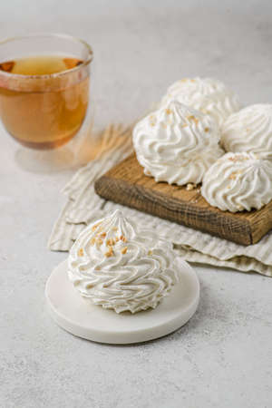 meringue on a wood and one piece on the white plate on white background with tea.の写真素材