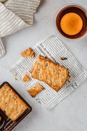 a stack of shortbread cookies with raisins and tea on a white background with the towel. A box with...