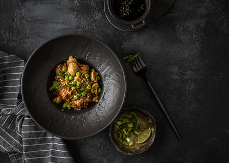buckwheat noodles with mushrooms on a dark background. In coconut milk sauce with ginger, green onion and sesame seeds. copy spaceの写真素材