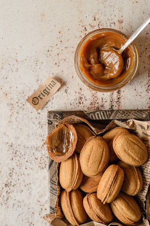 cookies nuts with boiled condensed milk in a brown box. a jar with condensed milk and a spoon next...