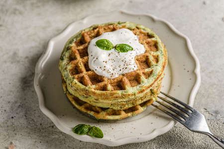 zucchini waffles with sour cream. Waffles are decorated with sour cream and basilの写真素材