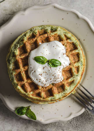zucchini waffles with sour cream. Waffles are decorated with sour cream and basilの写真素材