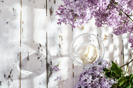 ice cream is in a glass, nearby lilac. The glass is on a white wooden table topの写真素材