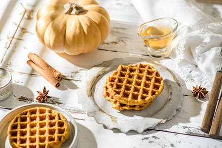pumpkin waffles on a white wooden background. waffles made from pumpkin puree, eggs and flour, with the addition of cinnamon, clovesの写真素材
