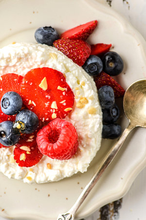 cottage cheese with raspberries, strawberries and blueberries. Cottage cheese is laid out in the...