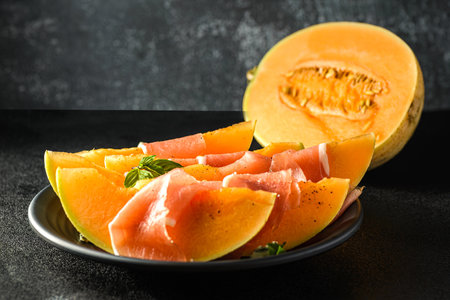 melon with parma on a dark background. high quality photoの写真素材