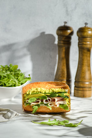 avocado and parma sandwich. baguette sandwich in craft packaging for deliveryの写真素材