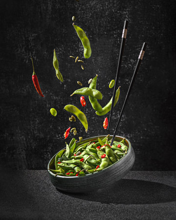 edamame bean salad in pods with chili pepper on a black backgroundの写真素材