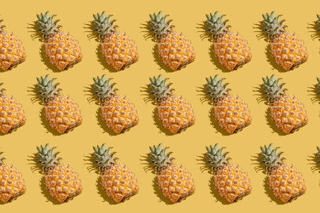 pineapple on a yellow background pattern, pineapple laid out on the backgroundの写真素材