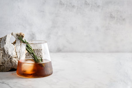 a glass of whiskey with ice on a light marble background. high quality photoの写真素材