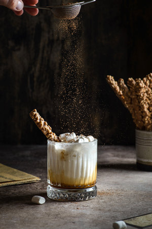 milk with caramel on a dark background sprinkle cocoa on top . high quality photo