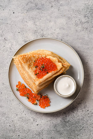 crepes with red caviar and sour cream. High quality photo