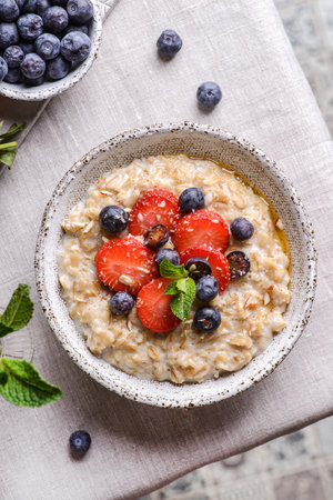 oatmeal porridge with strawberries blueberries and honeyの写真素材
