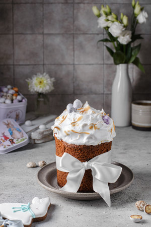 Easter cake decorated with meringue and chocolate eggs on gray background, minimalism style
