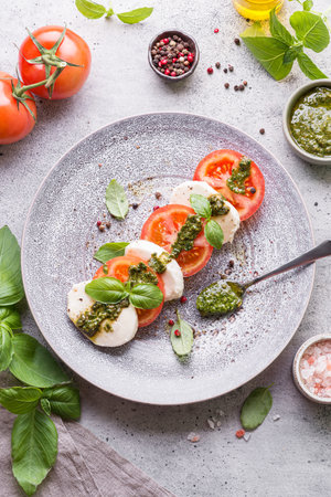 tomatoes with mozzarella with basil and pesto sauceの写真素材