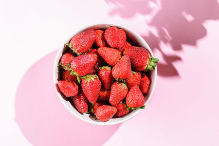 strawberries in a bowl on a pink background. High quality photo