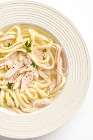 chicken noodle soup with herbs in a white bowl. High quality photoの写真素材