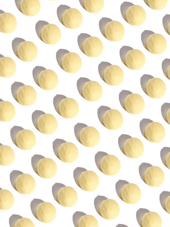 a pattern of chocolates bonbons with white chocolate on a white background with modern harsh lightの写真素材