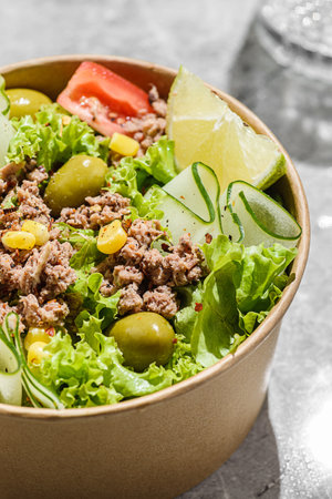 salad with tomatoes, cucumber and olives in a cardboard container. High quality photoの写真素材
