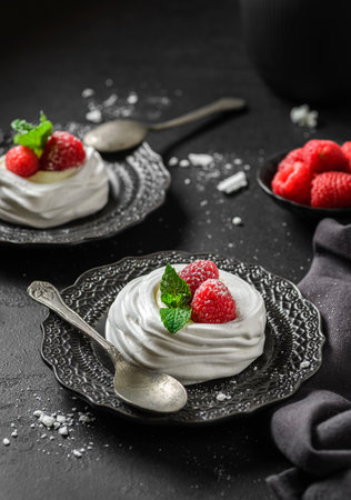 Pavlova meringue dessert with raspberries and cream. The dessert is made from egg whites and powdered sugar, as well as whipped cream and cottage cheese.の写真素材