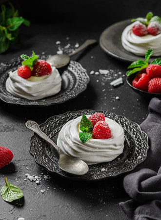 Pavlova meringue dessert with raspberries and cream. The dessert is made from egg whites and powdered sugar, as well as whipped cream.の写真素材