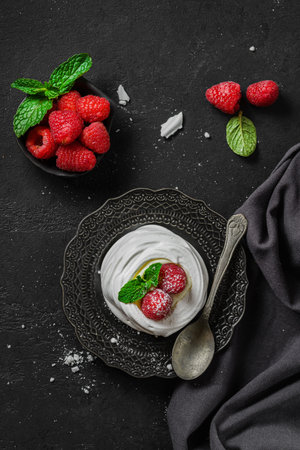 Pavlova meringue dessert with raspberries and cream. The dessert is made from egg whites and powdered sugar, as well as whipped cream and cottage cheese.の写真素材