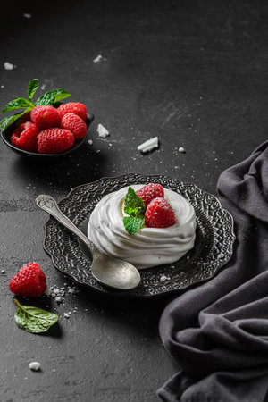 Pavlova meringue dessert with raspberries and cream. The dessert is made from egg whites and powdered sugar, as well as whipped cream and cottage cheese.の写真素材