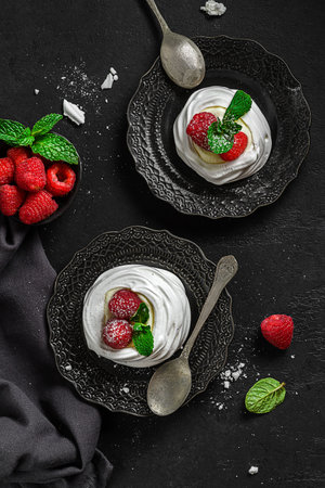Pavlova meringue dessert with raspberries and cream. The dessert is made from egg whites and powdered sugar, as well as whipped cream and cottage cheese.の写真素材