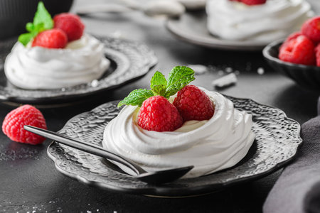 Pavlova meringue dessert with raspberries and cream. The dessert is made from egg whites and powdered sugar, as well as whipped cream.の写真素材