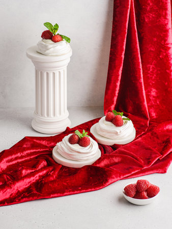 Pavlova meringue dessert with raspberries and cream. The dessert is made from egg whites and powdered sugar, as well as whipped cream. Decorated raspberry and mintの写真素材