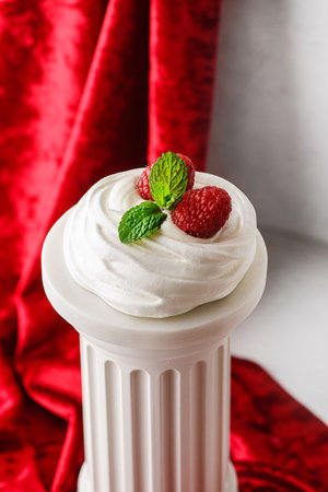 Pavlova meringue dessert with raspberries and cream. The dessert is made from egg whites and powdered sugar, as well as whipped cream. Decorated raspberry and mintの写真素材