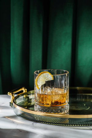 a glass of whiskey on the table is decorated with lemon. High quality photoの写真素材