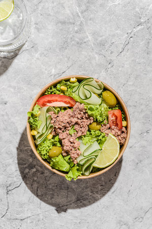 salad with tuna, tomatoes, cucumber and olives in a cardboard container. High quality photoの写真素材