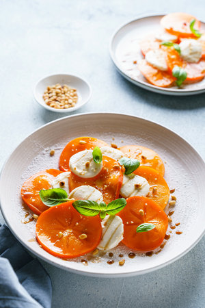 caprese salad with persimmon and mozzarella. High quality photoの写真素材
