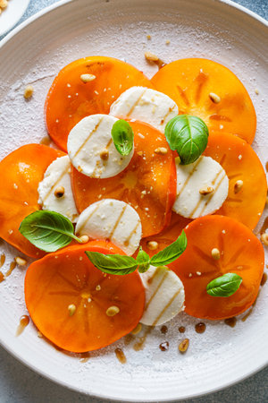 caprese salad with persimmon and mozzarella. High quality photoの写真素材