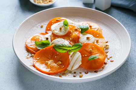 caprese salad with persimmon and mozzarella. High quality photoの写真素材