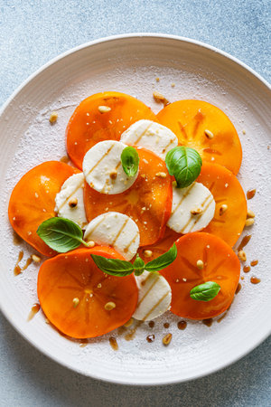 caprese salad with persimmon and mozzarella. High quality photoの写真素材