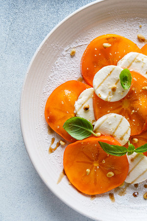 caprese salad with persimmon and mozzarella. High quality photoの写真素材