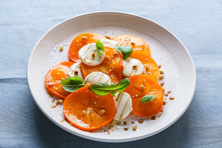 caprese salad with persimmon and mozzarella. High quality photoの写真素材