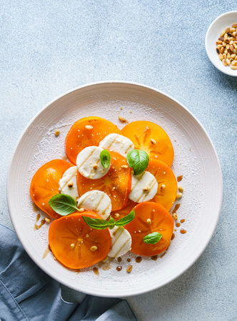 caprese salad with persimmon and mozzarella. High quality photoの写真素材