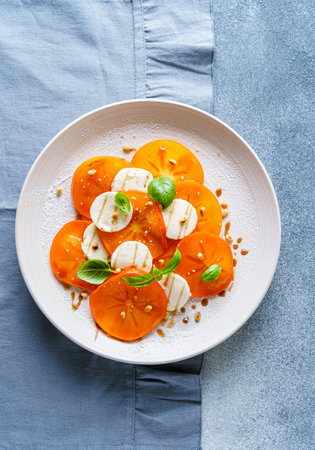 caprese salad with persimmon and mozzarella. High quality photoの写真素材