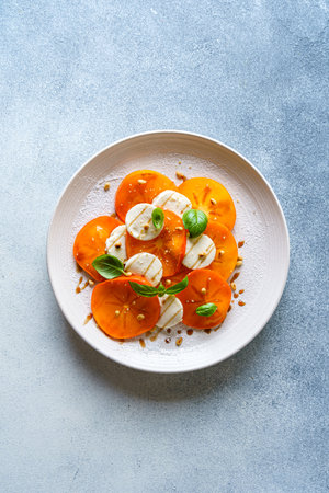 caprese salad with persimmon and mozzarella. High quality photoの写真素材