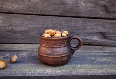 hazelnuts in a clay cupの写真素材
