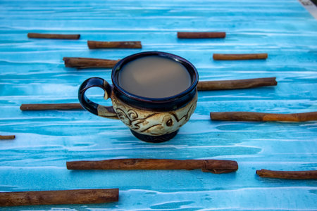 coffee with milk, cinnamon and blue background