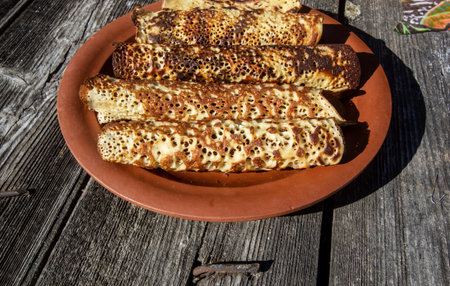 thin openwork pancakes on a clay plate