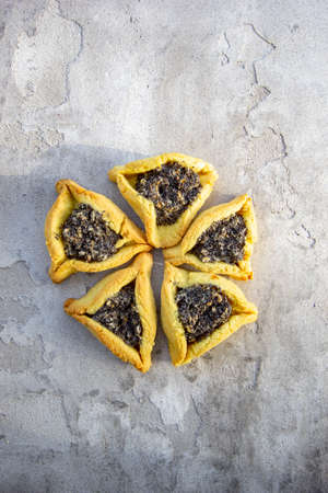 hamantaschen cookies. Jewish traditional baked goods for Purim (Jewish carnival holiday with celebration concept). Homemade cookies with poppy seeds fillingの写真素材